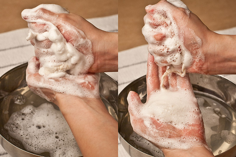 rubbing soap nuts in between hands to form suds